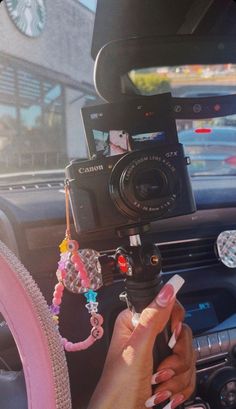 a woman holding a camera in her car