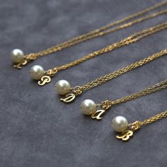 "This set of bridesmaid necklaces makes a lovely gift for your girls.  A lustrous, 8mm Swarovski crystal pearl, accented by a fancy script initial in 14kt gold fill dangles from sparkling 14kt gold fill chain.  This listing is for eight (8) necklaces. The price of each necklace has been reduced from $26 to $22.10, a 15% discount. Most of the pieces in my shop are available in multiples for your bridal party. If you don't see the piece or quantity you'd like, please contact me: https://www.etsy.c Gold Bridesmaid Necklace, Gold Bridesmaid Jewelry, Bridesmaid Jewelry Gift, Bridesmaid Necklace Gift, Personalized Gold Necklace, Tiffany And Co Necklace, Silver Bridesmaid, Bridesmaids Gift Sets, Script Initial