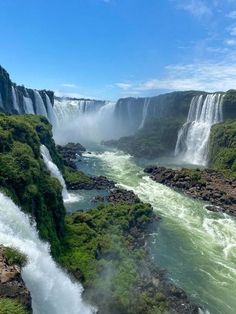 iguana falls in the background with green vegetation and water flowing down it's sides