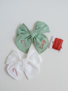 two pieces of fabric with the words merry written on them next to a pair of scissors