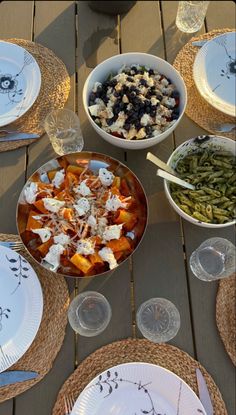 a table with plates, bowls and glasses on it