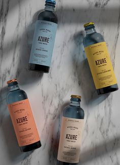 four bottles of water sitting on top of a marble counter