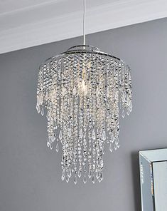 a crystal chandelier hanging from the ceiling in a room with gray walls and white trim