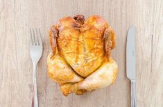 a whole chicken sitting on top of a wooden table