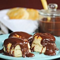 two pieces of chocolate covered pastry on a blue plate next to some cookies and dipping sauce