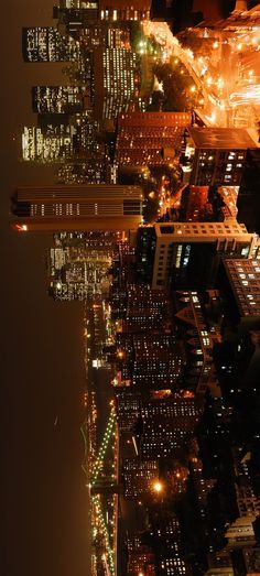 an aerial view of the city at night from high up in the sky, looking down on skyscrapers