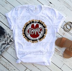 a white shirt with leopard print and the words red hots on it, next to sandals