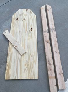 two pieces of wood sitting on top of a cement floor next to wooden planks