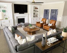 a living room filled with furniture and a flat screen tv mounted on the wall over a fireplace