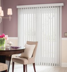 a dining room with purple walls and white vertical blinds