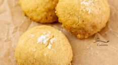 three cookies sitting on top of a piece of wax paper with powdered sugar on them