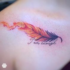 a tattoo with an orange feather and the words i am enough written in cursive ink