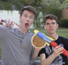 two young men are making funny faces while holding food items