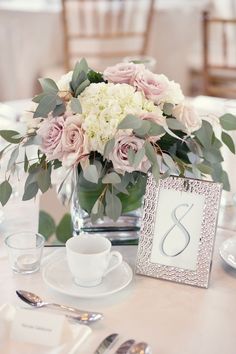 a vase filled with flowers on top of a table next to a plate and cup