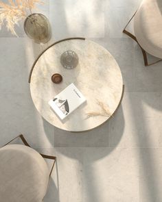 a table with two chairs and a book on it in the middle of a room