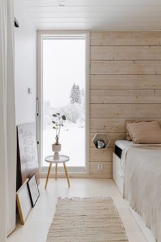 a bedroom with wood paneling and white walls