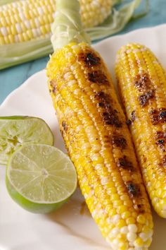 grilled corn on the cob with lime wedges next to it and two slices of lime