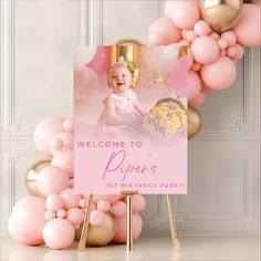 a welcome sign with balloons and a baby's first birthday photo in the center