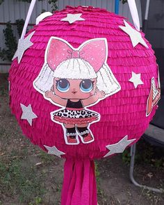 a pink pinata with an image of a doll on it's face and stars