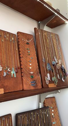 jewelry is displayed on wooden shelves in a store