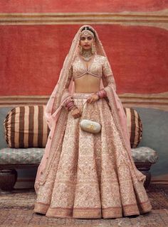 a woman in a bridal gown standing next to a couch