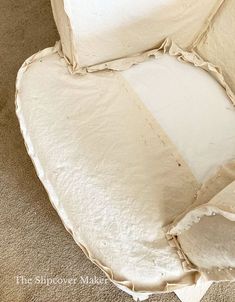 the corner of a white chair that has been torn off and is sitting on carpet