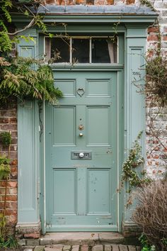 a green door is shown in front of a brick building with ivy growing on it