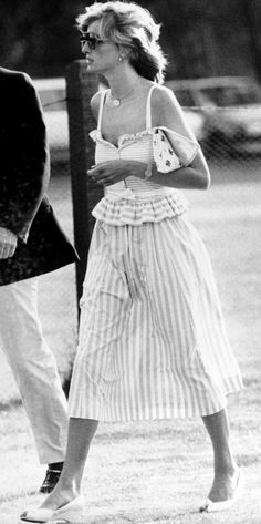 a woman walking across a field next to a man