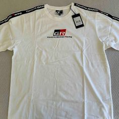 Offering A Nwt Tee From The Toyota Gazoo Racing Team. High Quality With Clothpatch Striping On Arm Sleeves And Fine Cotton Material. Will Be Posting Tees From My Brothers Collection All Day, So Get Bundling! White Short Sleeve Tops With Three Stripes Branding, White Graphic Tee With Three Stripes Branding, Cotton Crew Neck Tops With Three Stripes Branding, White Casual Top With Three Stripes Branding, Casual White Top With Three Stripes Branding, Gazoo Racing, Arm Sleeves, Racing Team, Arm Sleeve