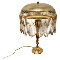 an antique brass table lamp with beaded glass shades on the top and bottom part