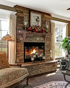 a living room filled with furniture and a fire place in front of a window on top of a brick fireplace