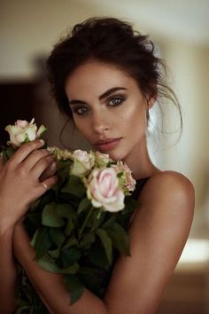 a beautiful young woman holding flowers in her hands