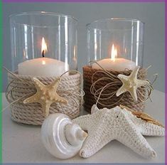 two glass vases filled with candles and seashells