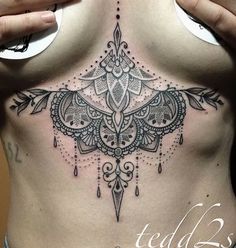 a woman's stomach with an intricate tattoo design on her chest and the bottom