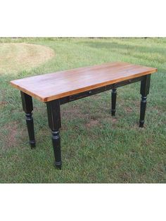 a wooden table sitting on top of a lush green field