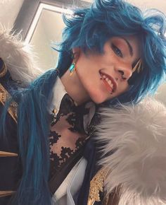 a woman with blue hair and piercings posing for the camera