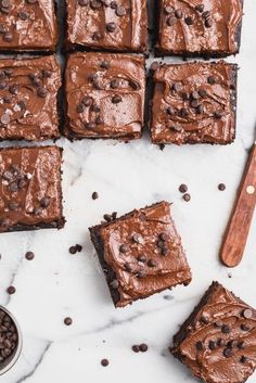 brownies with chocolate frosting on a marble surface