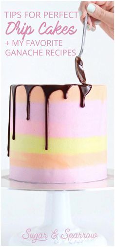 a pink and yellow cake with chocolate drizzled on top is being cut