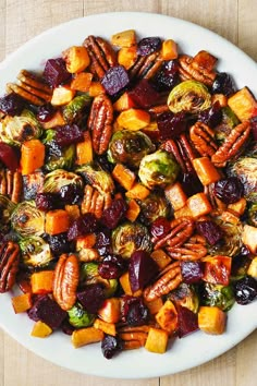 a white plate topped with brussel sprouts and roasted vegetables