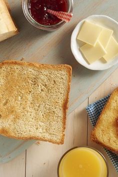 two slices of bread, butter and jam on a table