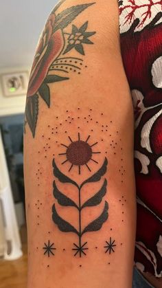 a woman's arm with tattoos on it, and a flower in the center