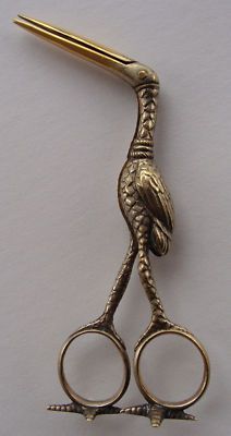 a pair of scissors with a bird on it's head and two pairs of handles