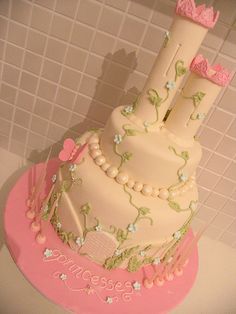 a three tiered cake is decorated with pink and green flowers on the bottom layer