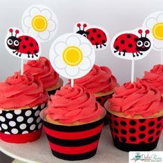 cupcakes with red frosting and ladybug decorations