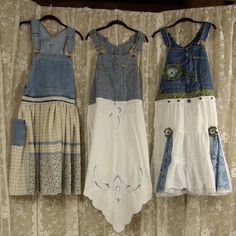 three dresses hanging on a clothes line in front of a curtain