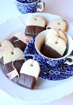 some cookies are in the shape of heart shaped tags on a blue and white plate