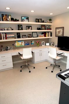 a home office with two white chairs and a piano in the middle of the room