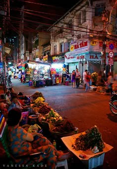 an outdoor market with people shopping at night