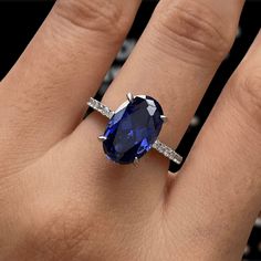 a woman's hand with a ring on it and a blue stone in the middle