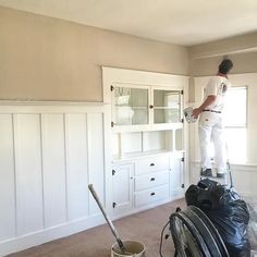 a man standing on top of a bucket in a room